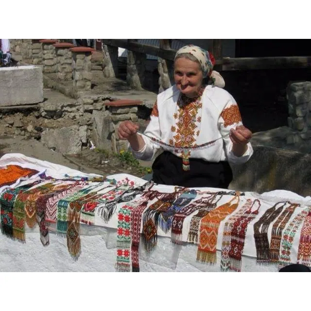 A woman displaying handmade beaded gerdan necklaces at a market stall
