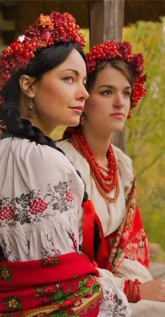Two women in elaborate floral crowns and embroidered Ukrainian folk dress