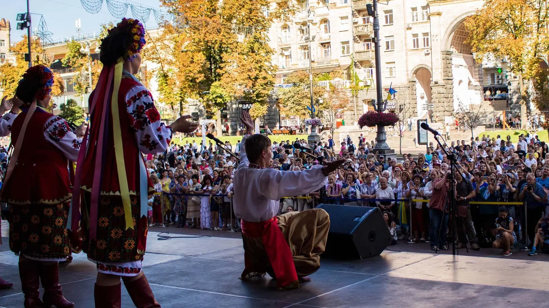 A dancer bowing to a large crowd at an outdoor performance in Kyiv